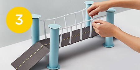 bridge made of cardboard with pipe cleaner support rails on the sides
