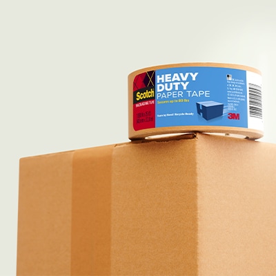 A roll of Scotch® Heavy Duty Paper Tape sitting on top of a cardboard box.