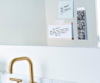 Photographs and notes taped to a kitchen wall.