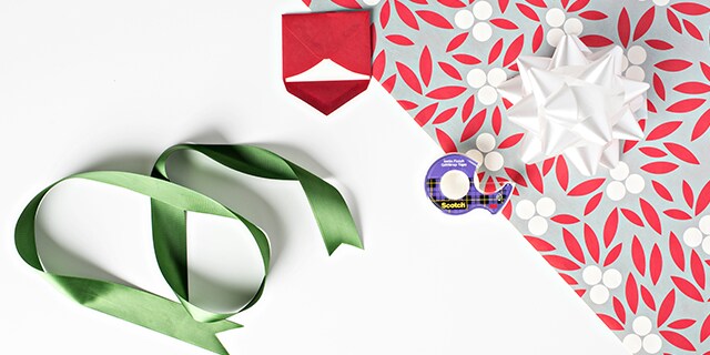 Clear tape on top of a present with ribbon on the side
