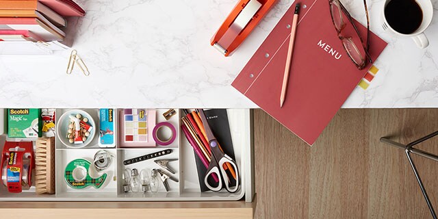A tabletop showcasing a variety of Scotch Brand products including shipping tape and super glue with a toolbox and a few tools,
