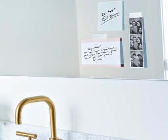 Des photographies et des notes collées sur un mur de cuisine.