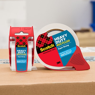 Scotch® Heavy Duty Recycled Packaging Tape in red dispensers displayed on cardboard.