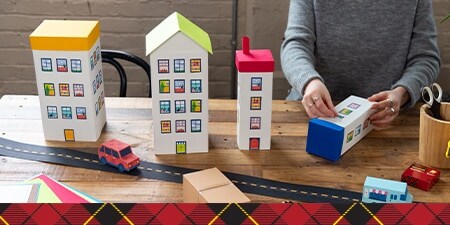 Paper buildings creating a city complete with stores, houses and skyscrapers.
