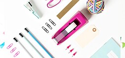 A tape dispenser surrounded by office supplies.