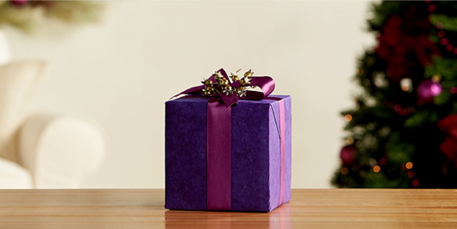 A gift wrapped with Premium Wrapping Paper in Purple and Berry-Coloured Satin Ribbon.