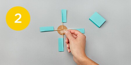 person holding a fan made of post-it notes
