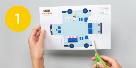 person cutting out automobile template from piece of paper
