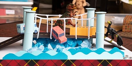 A DIY suspension bridge created with paper towel rolls and pipe cleaners.

