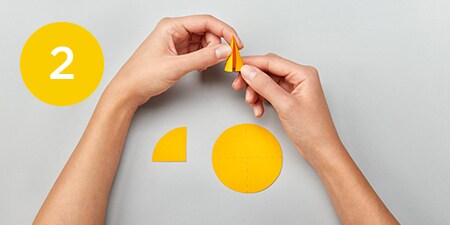 person taping a folded post-it® note to a straw
