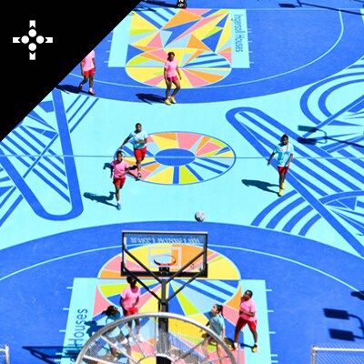 An overhead image of a colorful basketball court. An Icon representing the Community pillar in the top left: four circles positioned in a diamond shape.
